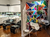 a salon with colorful chairs and a colorful wall